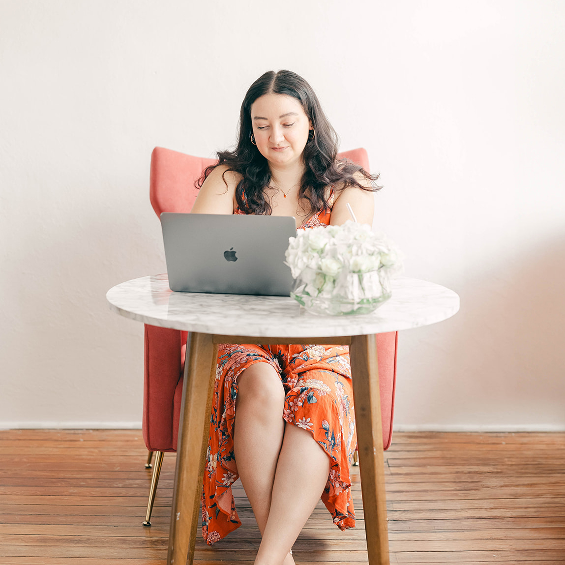 graphic designer at marble table working on laptop