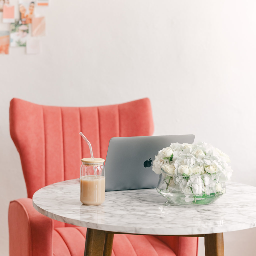 marble table with laptop, tea, and a brand mood board